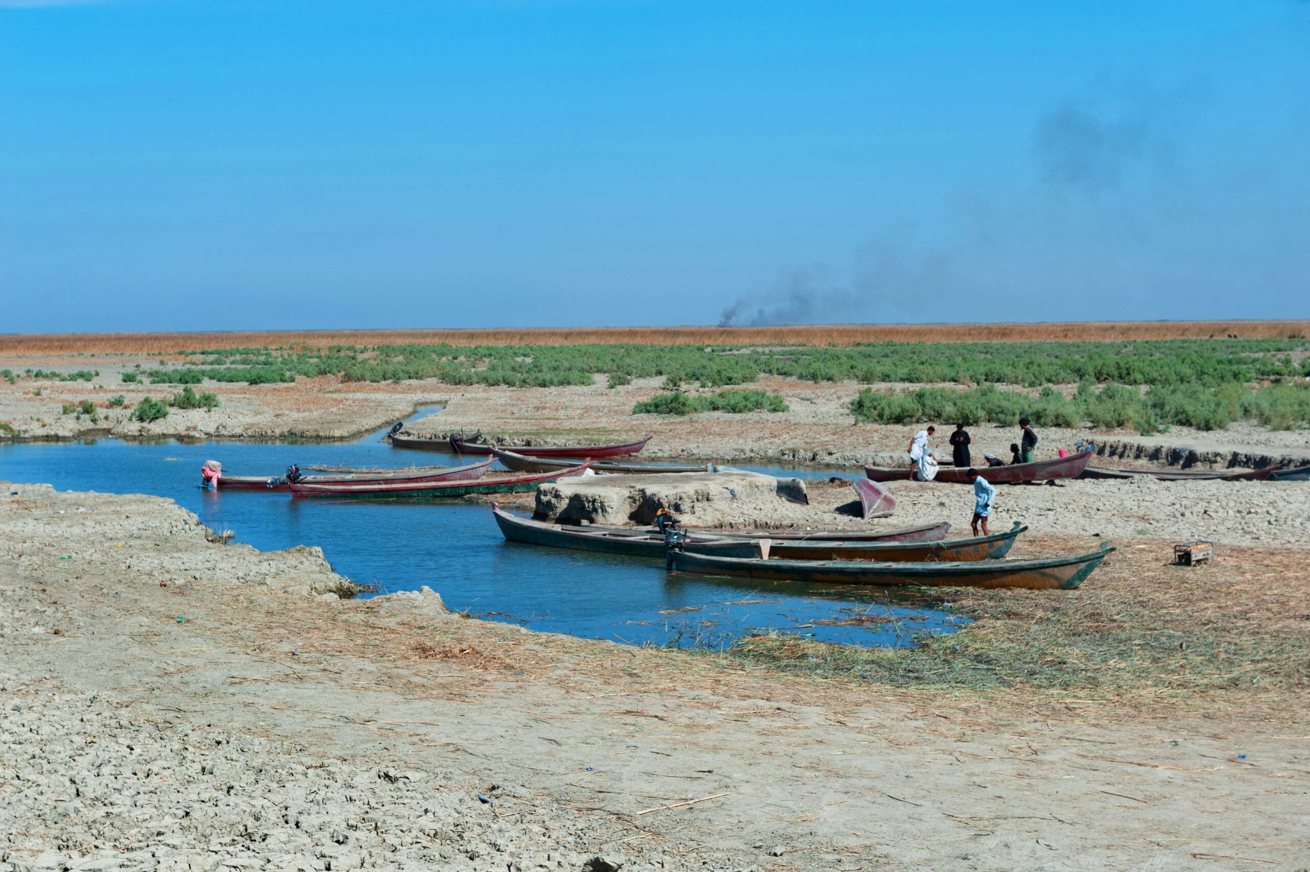 Al-Chibayish Iraq. November 1st 2018 Marsh Arab Fishermen with their Mashoof canoes moored at the edge of the dry cracked earth of the central marshes of southern Iraq, extreme weather causing drougt