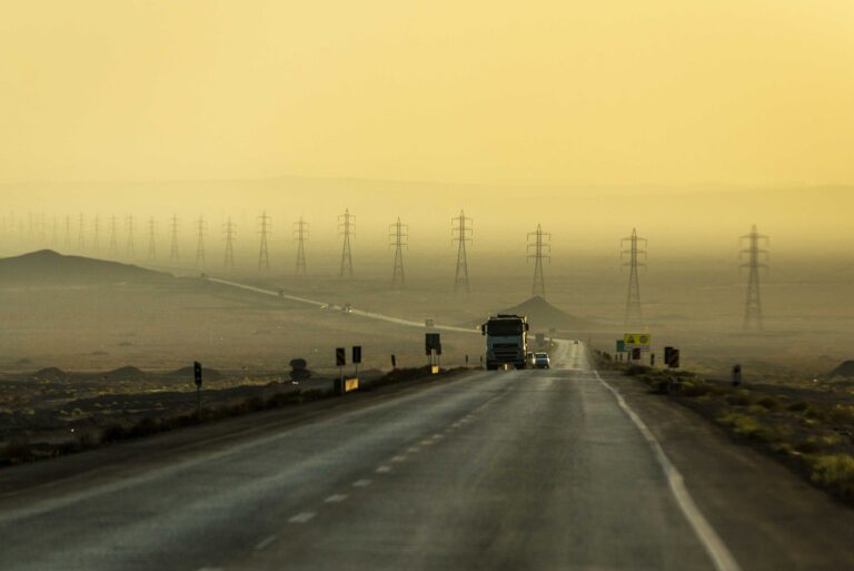 Foggy early morning in Iran with highway and power lines in the background.