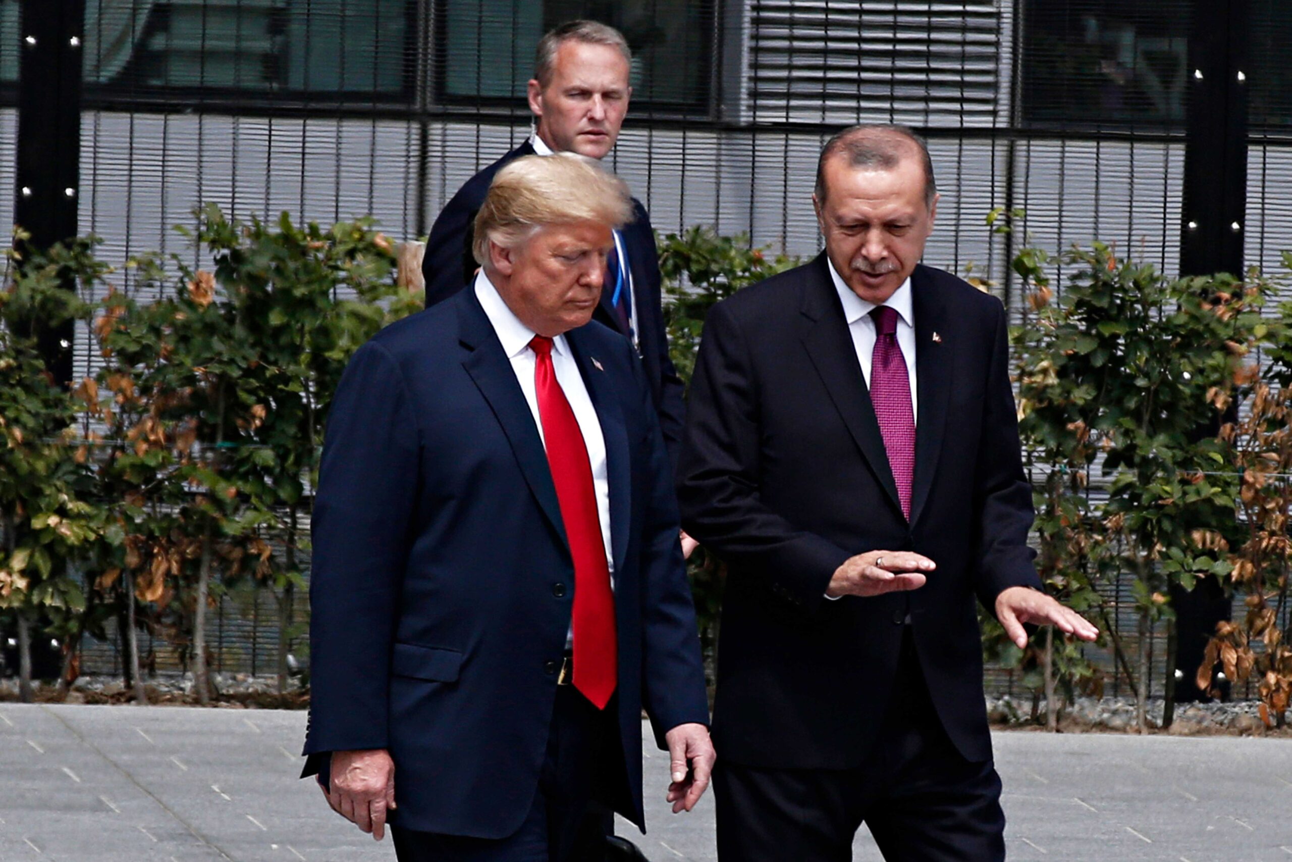 President Erdogan having a conversation with President Trump while walking outdoors.