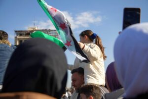 A girl on her father's shoulders with the new Syrian flag in her hand in Damascus, Syria.