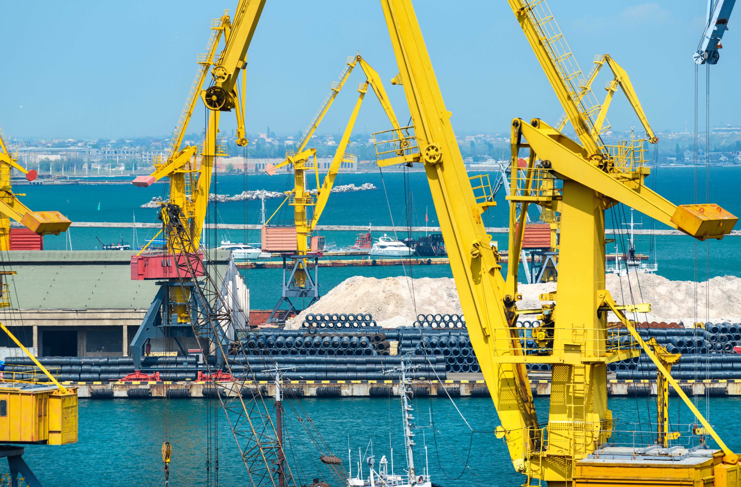 Industrial seaport infrastructure - sea, cranes and minerals, metal and bundles of wire, concept of marine cargo transportation.