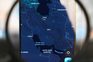 Magnifying glass over the map of Iran.