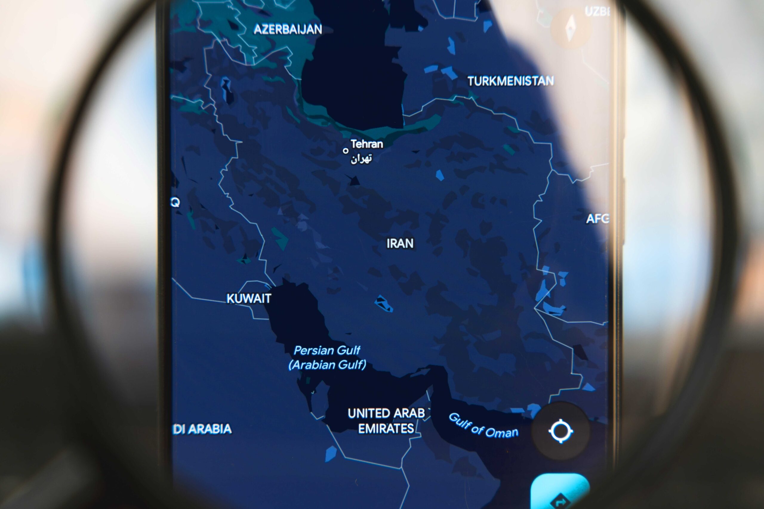Magnifying glass over the map of Iran.