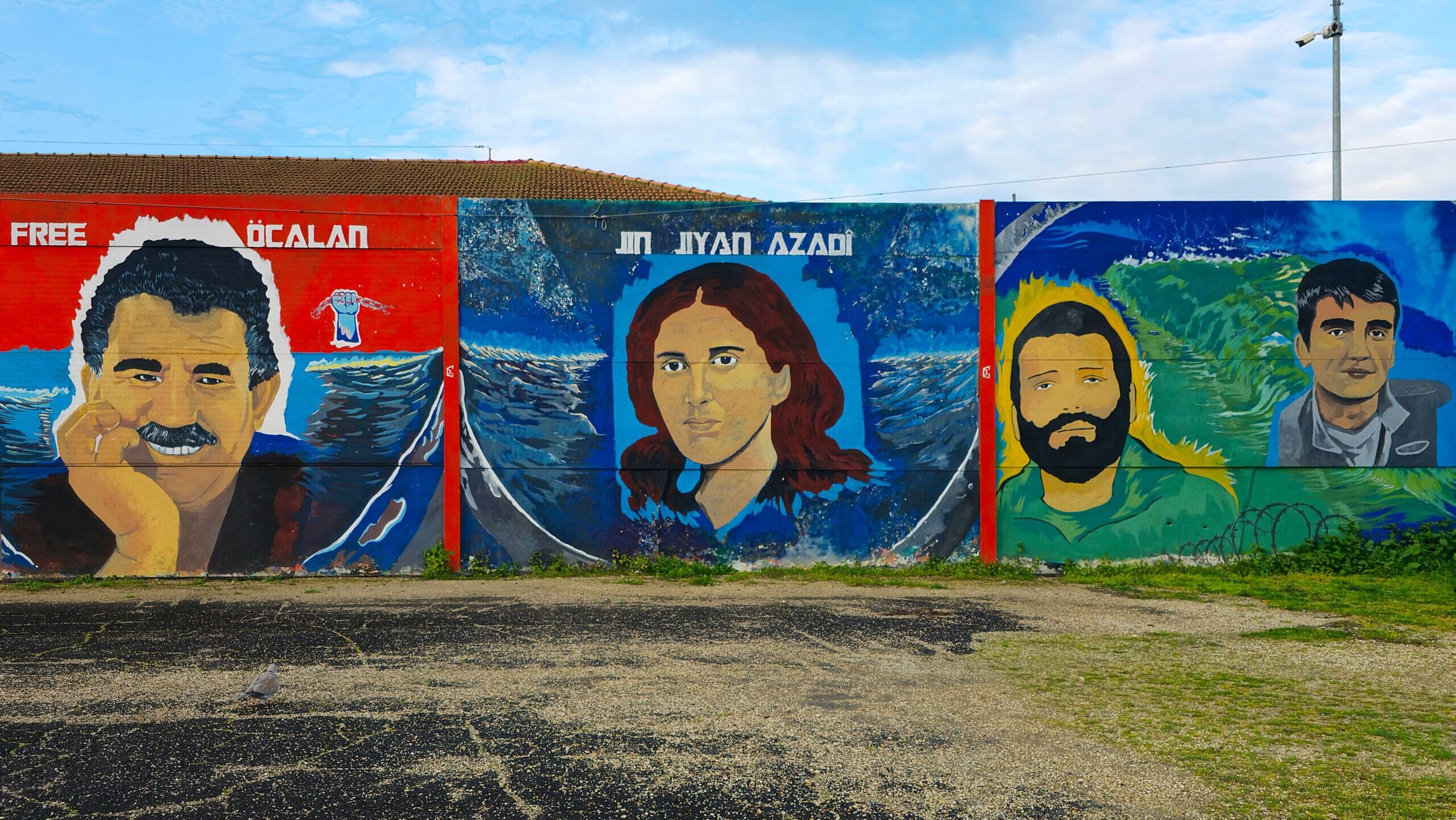 Abdullah Öcalan (PKK founder), a symbolic female fighter likely Sakine Cansız, and two Kurdish martyrs, painted in Largo Dino Frisullo, next to the Ararat Cultural Center, Rome, Italy, March, 30, 2025