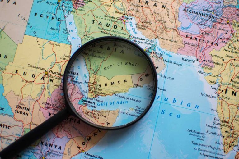Magnifying glass placed over a map of the Middle East, highlighting Yemen.