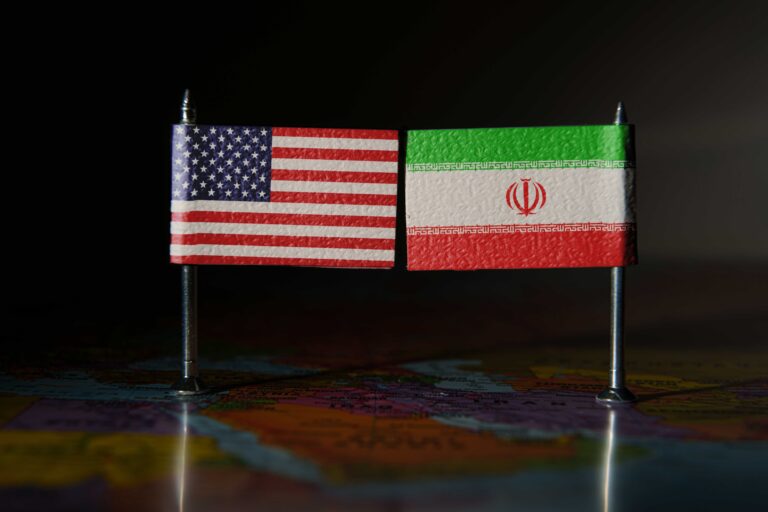 US and Iran flags over the map of the Middle East.