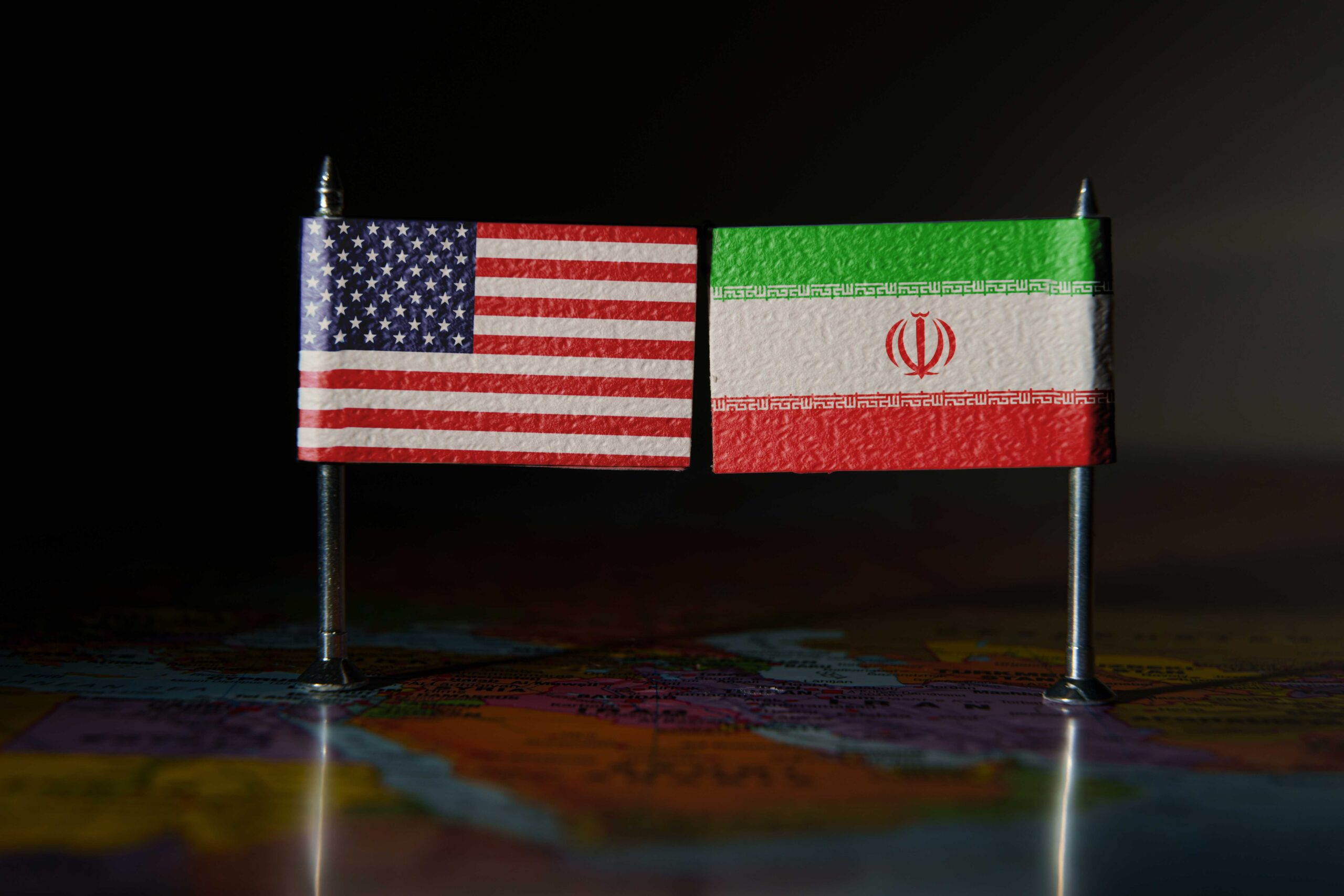 US and Iran flags over the map of the Middle East.