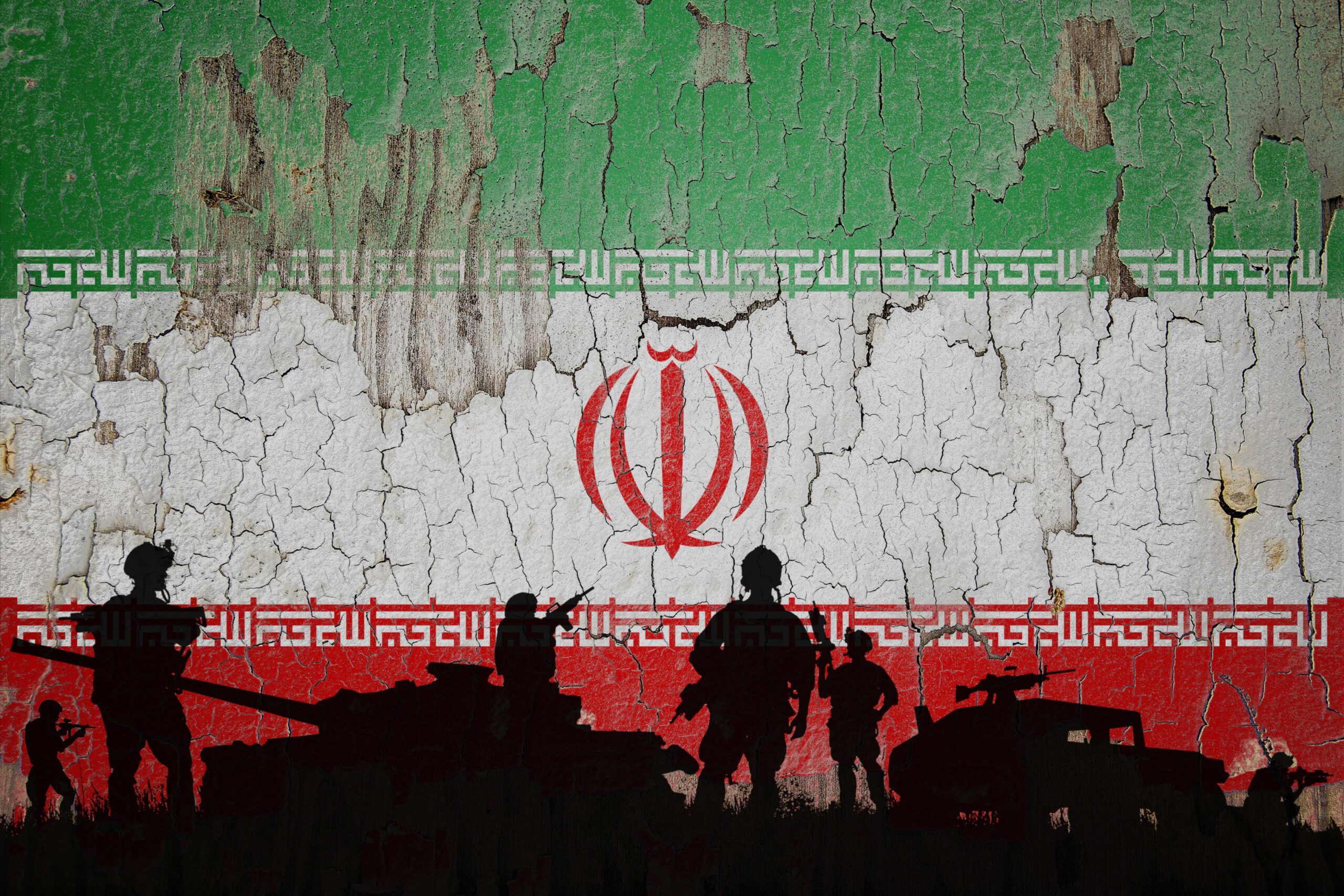 Iran flag painted on the cracked wall and soldiers shadow.