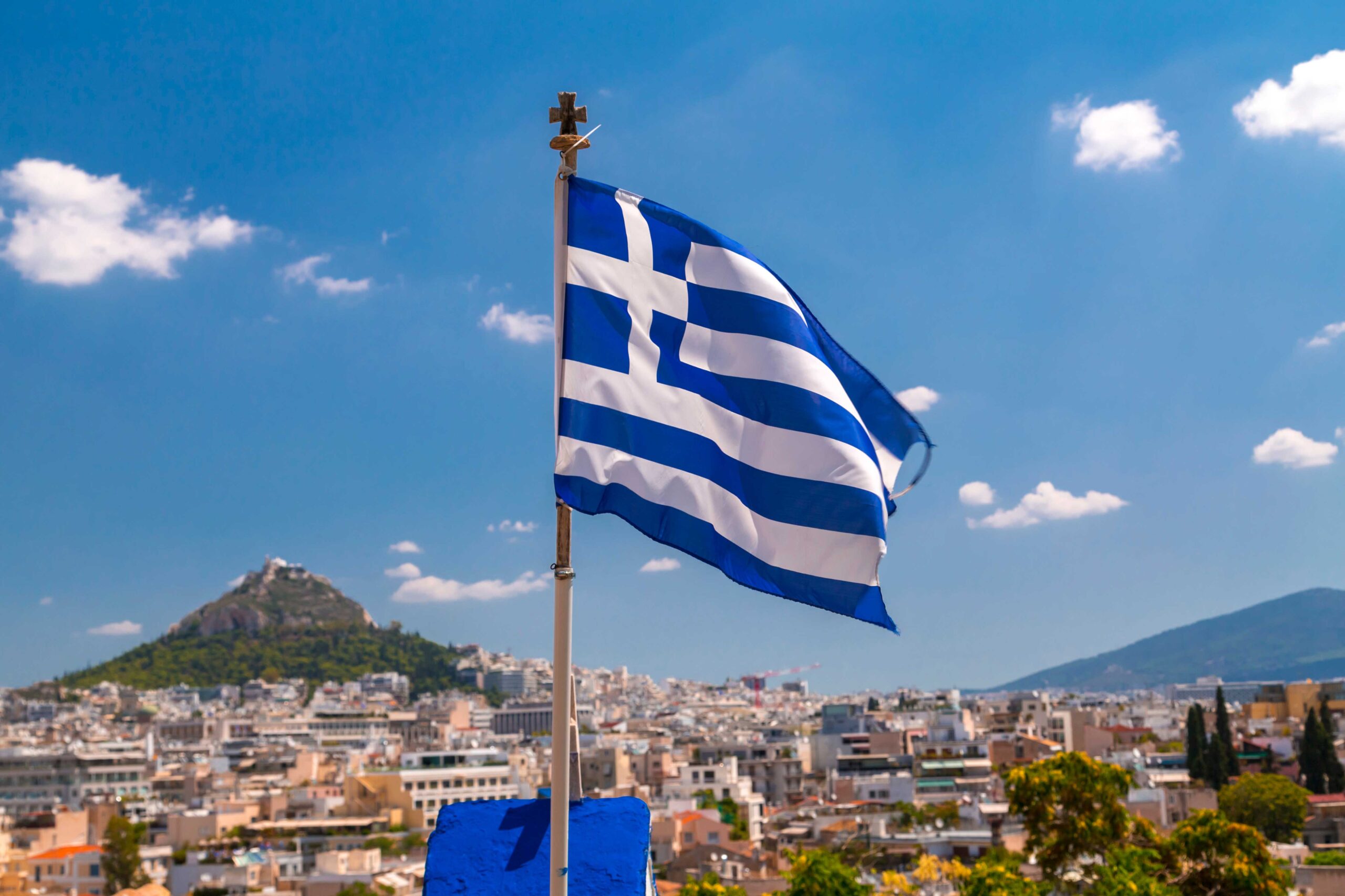 Greek flag waving waving over the city of Athens, the Greek capital