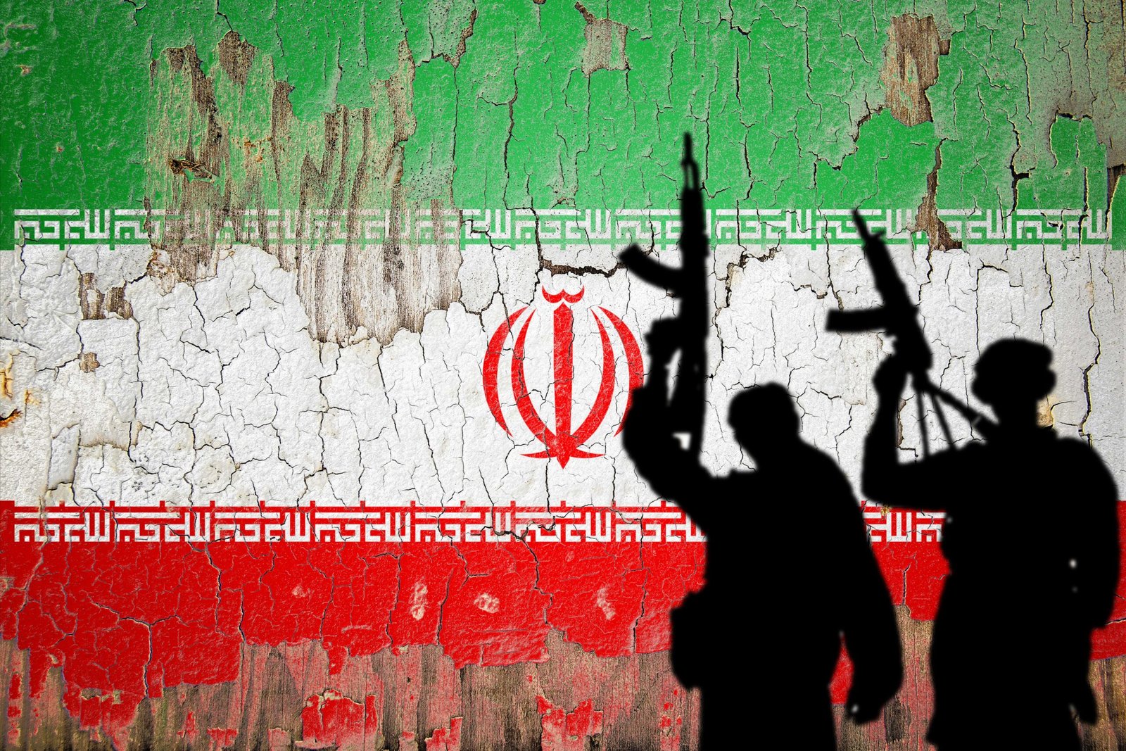 Flag of Iran painted on the cracked wall with terrorist shadow.
