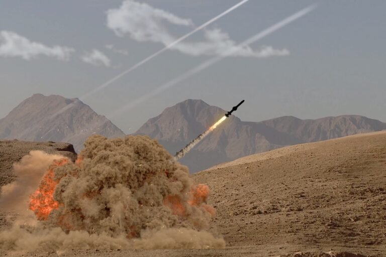The rocket soars into the sky, leaving behind a trail of smoke in the desert in the middle of the mountains.