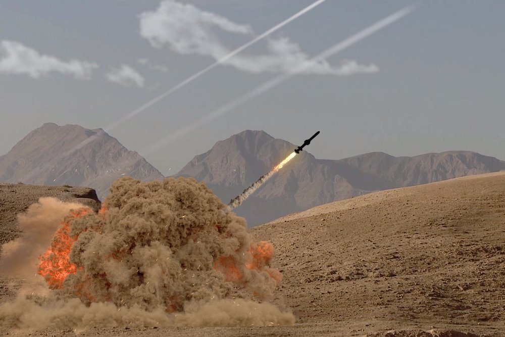 The rocket soars into the sky, leaving behind a trail of smoke in the desert in the middle of the mountains.